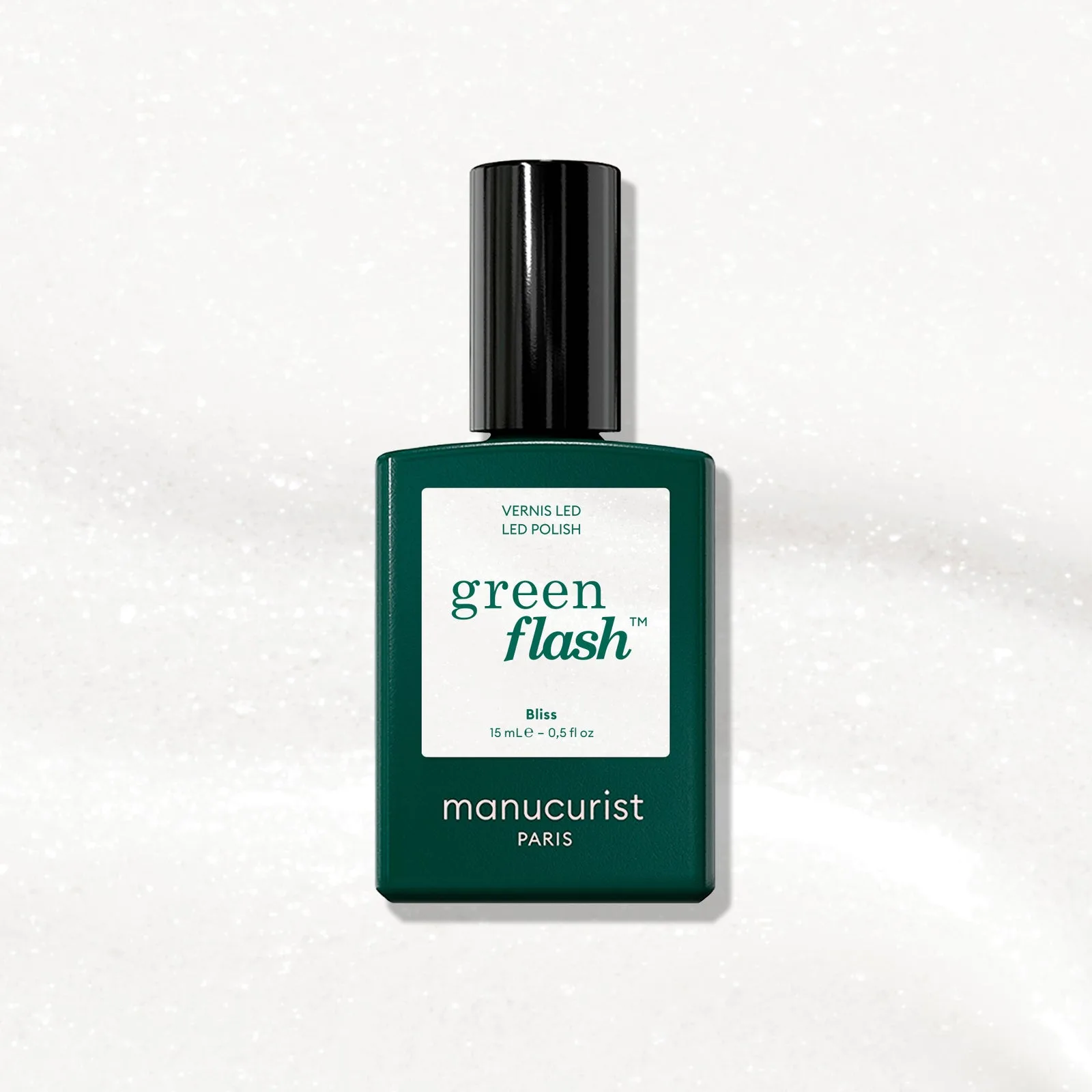 Lahvička Manucurist Green Flash Bliss na barevném pozadí